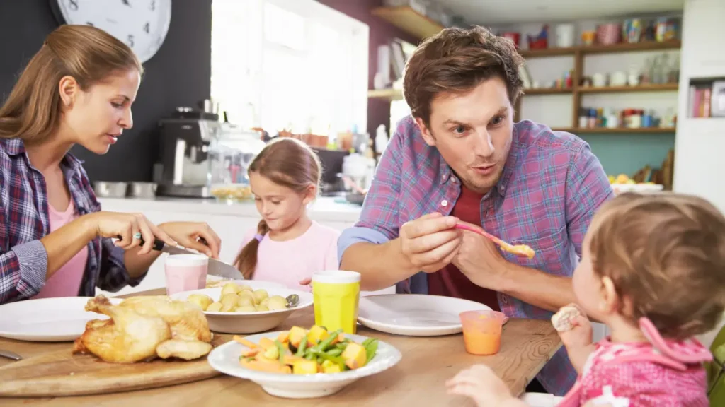 primeira alimentação do bebê, família comendo juntamente com o bebê na mesa